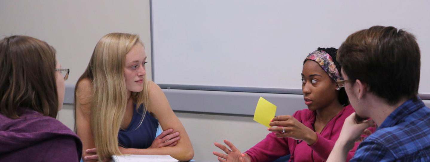 Student holds up sticky note during study session in the LRC